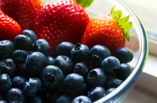 black berries served beside strawberry on clear glass bowl