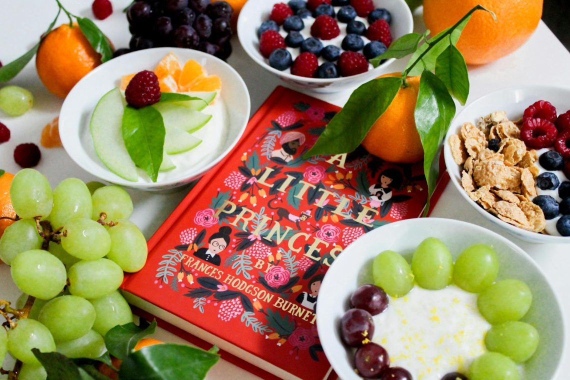 fruits on plates beside red book