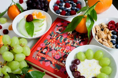 fruits on plates beside red book